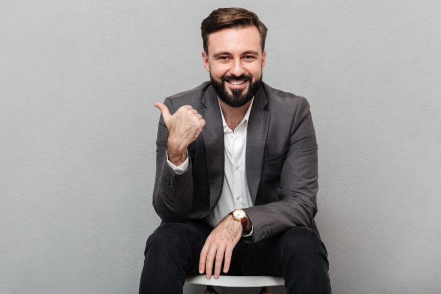Cropped portrait of joyful man resting on chair in office and ge