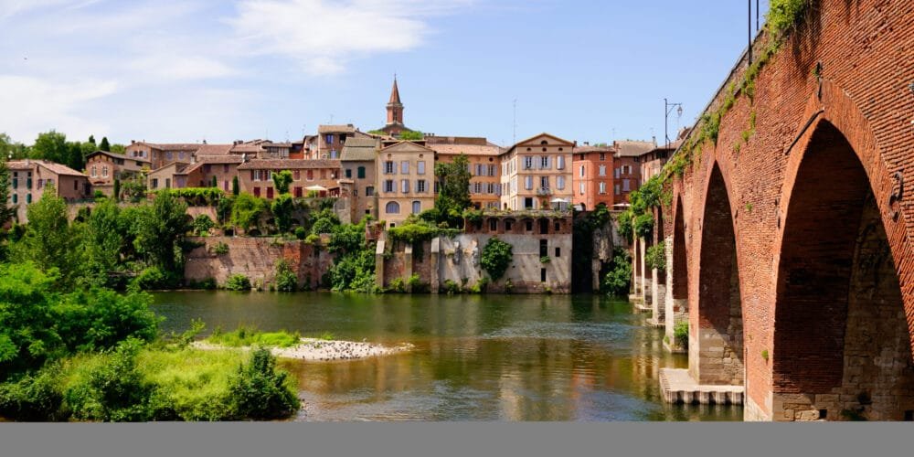 Albi view city and old red brick stone bridge over Tarn river in France